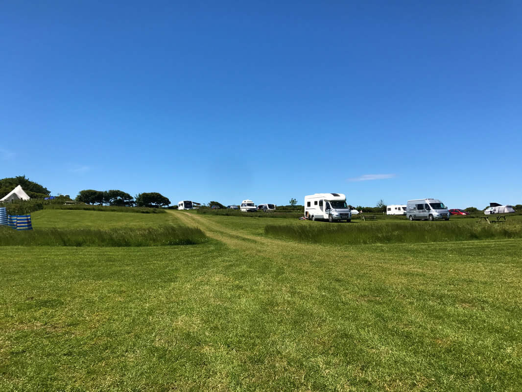 Wide open field on a caravan park, with caravans nearby