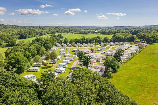 Image of a caravan park in a field, with the sun shining brightly