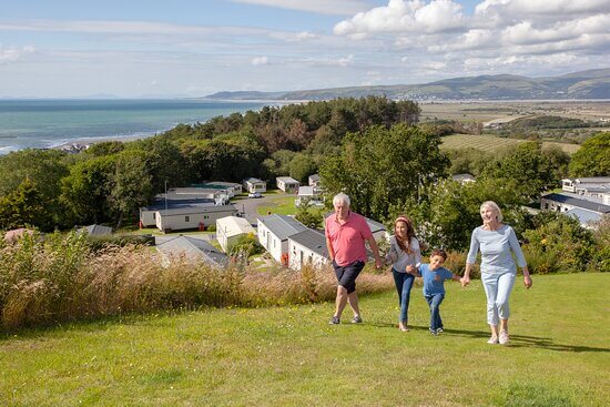 Four family members walking together overlooking a caravan park