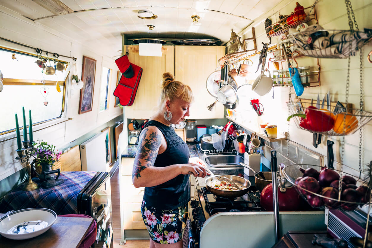 woman cooking in small narrowboat kitchen