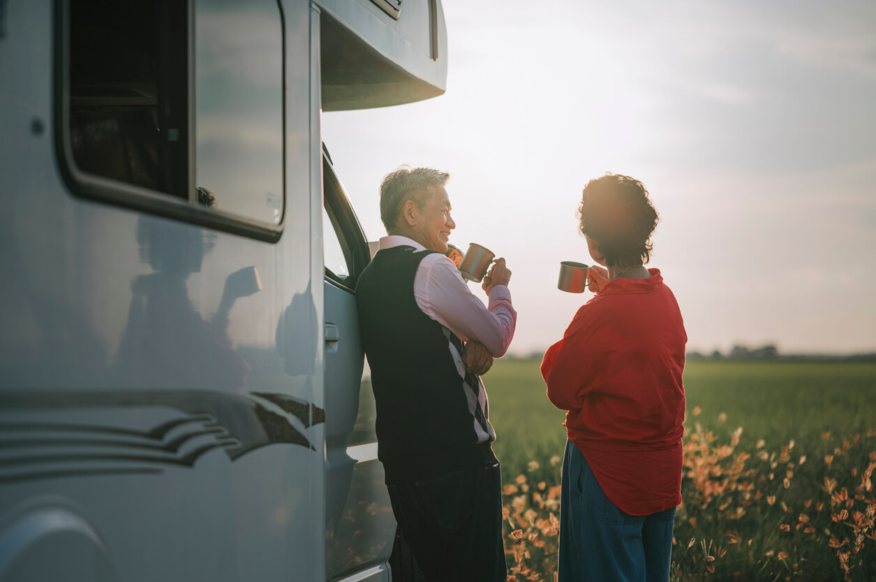 Two people discussing the motorhome market while drinking tea outside of their motorhome