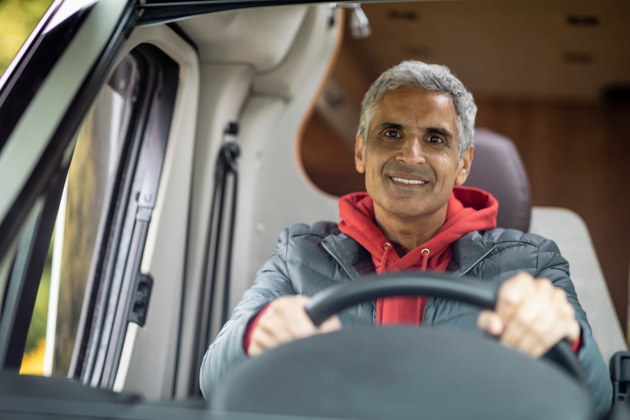 Man driving a motorhome with smiling face