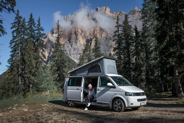 Elevating roof motorhome with lady sat watching over the countryside