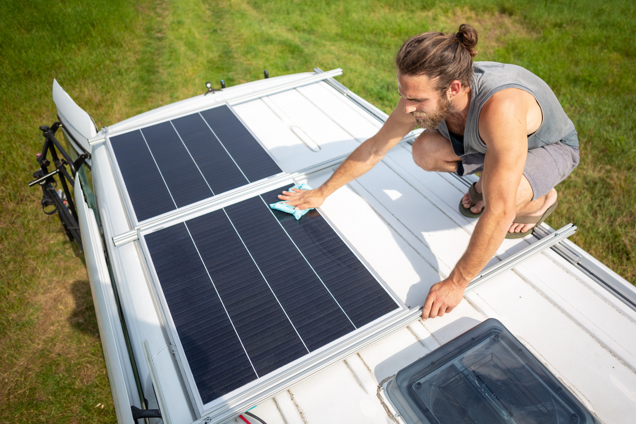 Man cleaning motorhome roof with cloth