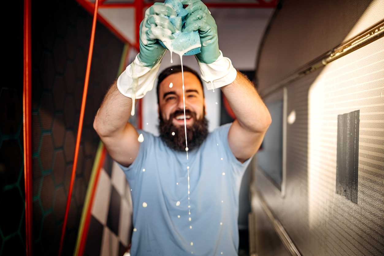 Man squeezing sponge with cleaning chemicals in