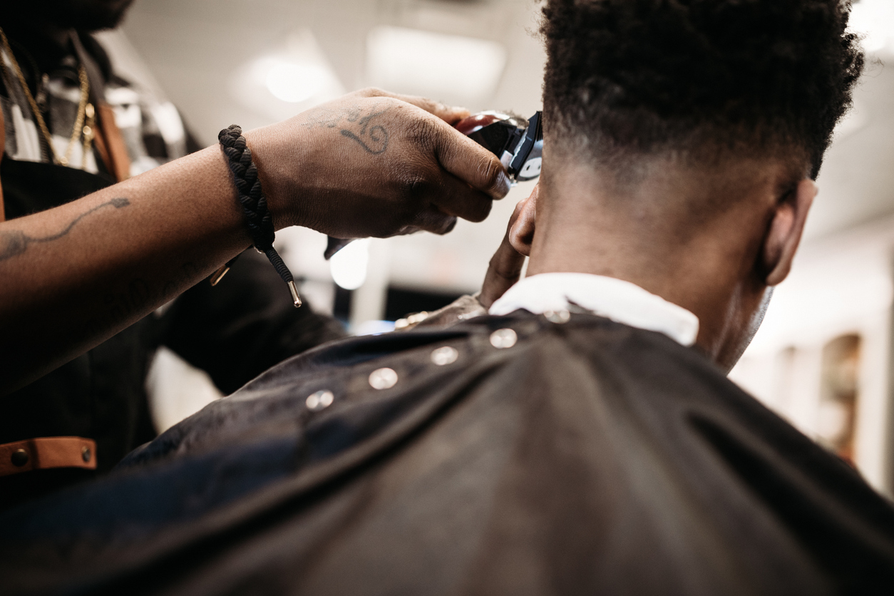 Man in barbers having hair cut with clippers and guards