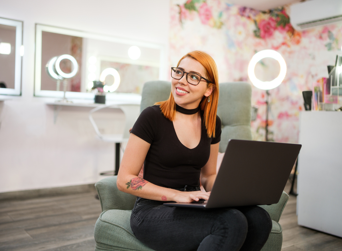 Lady at laptop in salon doing reviews